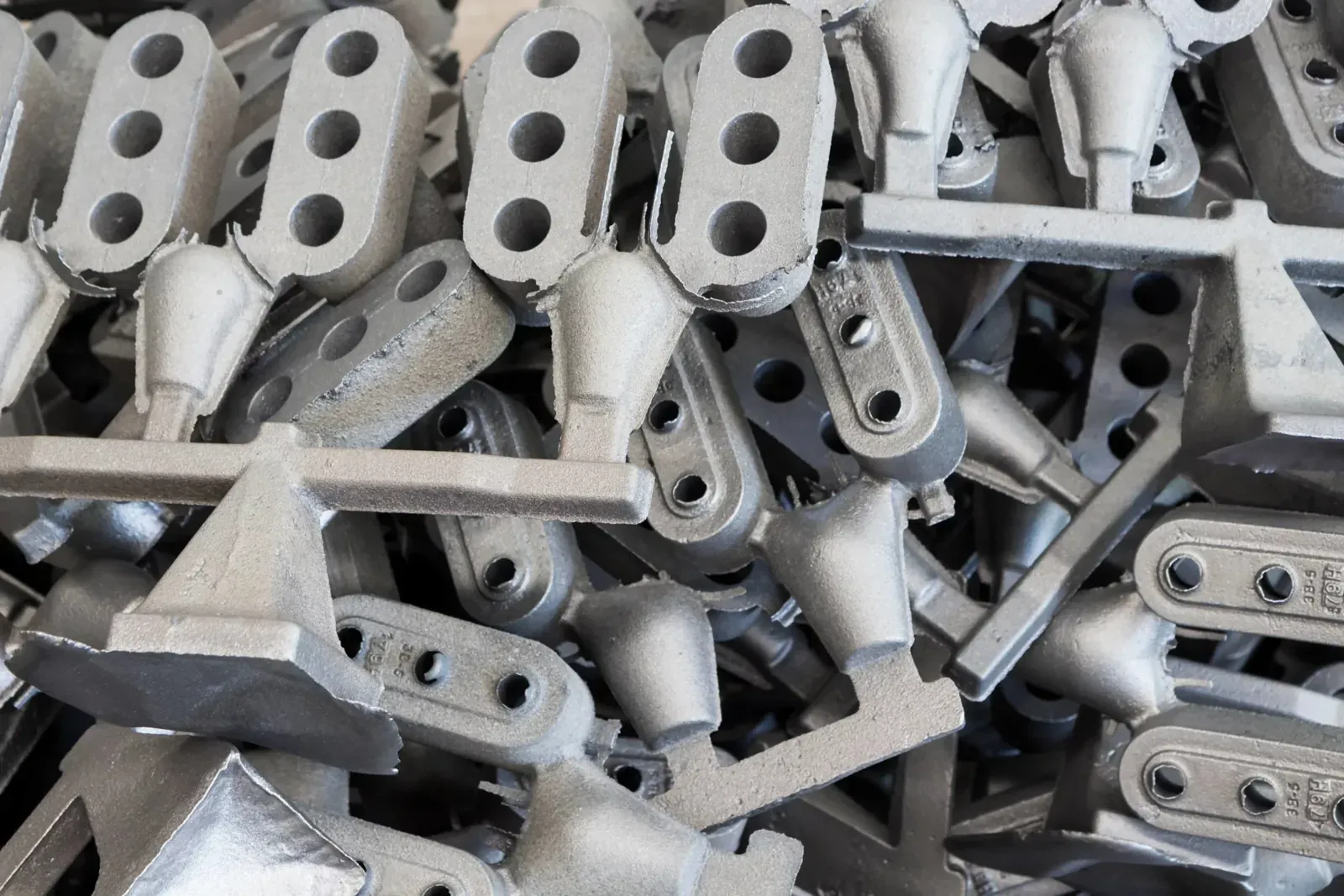 Finished cast aluminum arms stacked after casting
